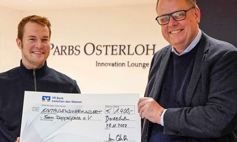 Jan Osterloh überreicht einen Spendenscheck ans Team Doppelpass